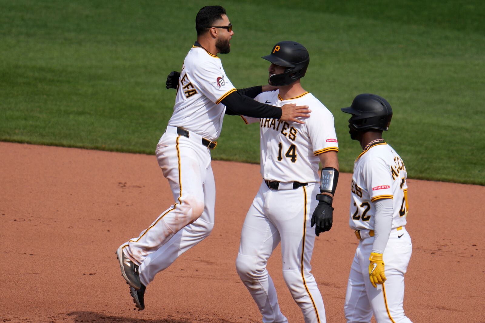 Pittsburgh Pirates' Joey Bart, center, celebrates with Andrew McCutchen, right, and Isiah Kiner-Falefa after driving in the game-winning run with a single off St. Louis Cardinals pitcher Chris Roycroft during the 13th inning of a baseball game in Pittsburgh, Wednesday, April 9, 2025. (AP Photo/Gene J. Puskar)