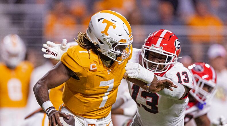 Tennessee quarterback Joe Milton III (7) is chased by Georgia defensive lineman Mykel Williams (13) during the second half of an NCAA college football game Saturday, Nov. 18, 2023, in Knoxville, Tenn. (AP Photo/Wade Payne)
