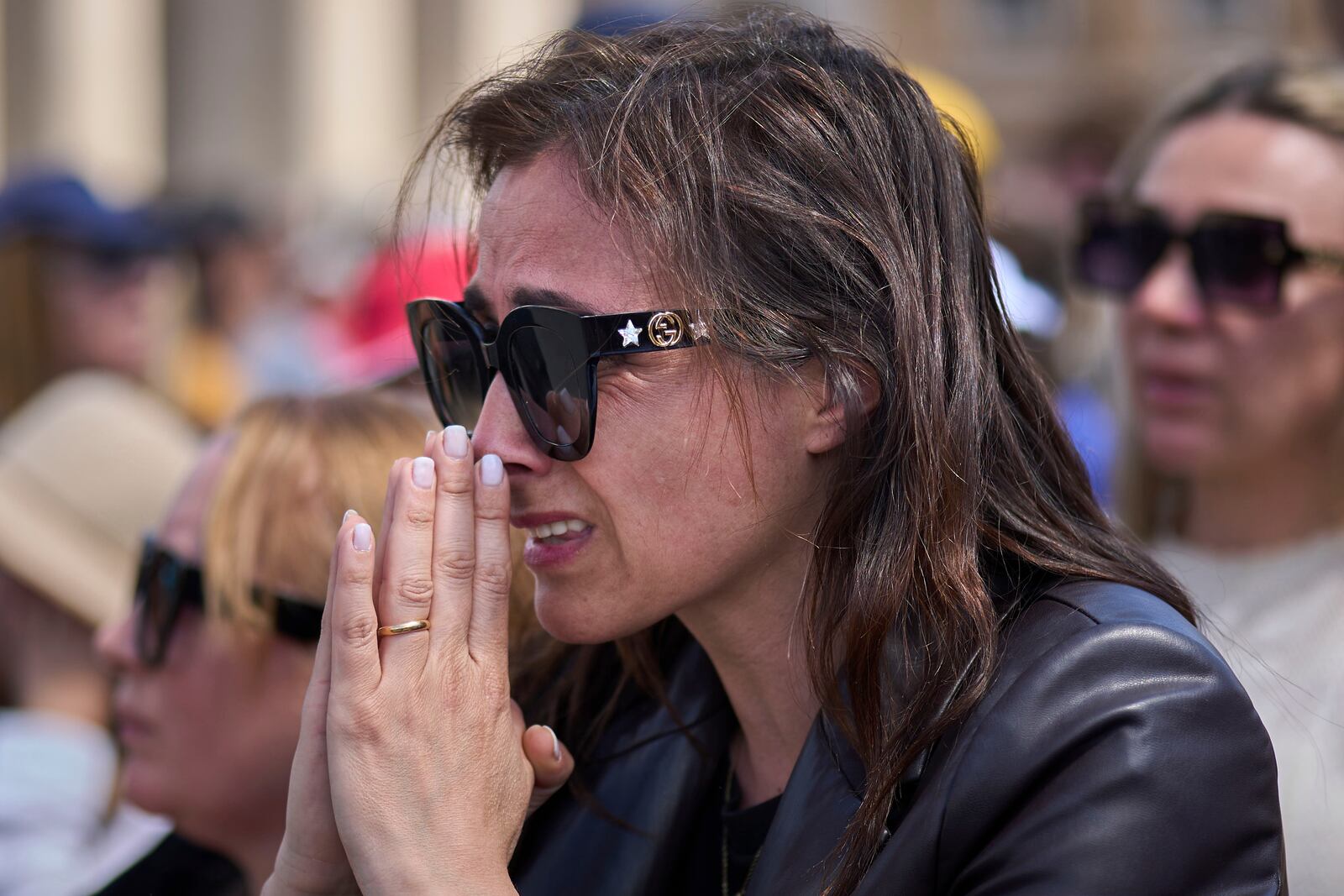 A faithful reacts during the funeral of Pope Francis in St. Peter's Square at the Vatican, Saturday, April 26, 2025. (AP Photo/Emilio Morenatti)