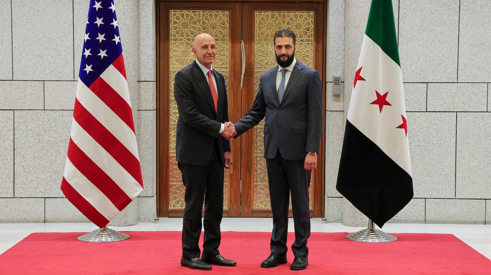 In this photo released by the Syrian official news agency SANA, Syria's interim President Ahmad al-Sharaa, right, shakes hands with U.S. Ambassador to Turkey and Special Envoy to Syria Tom Barrack, in Damascus, Syria, May 29, 2025. (SANA via AP)
