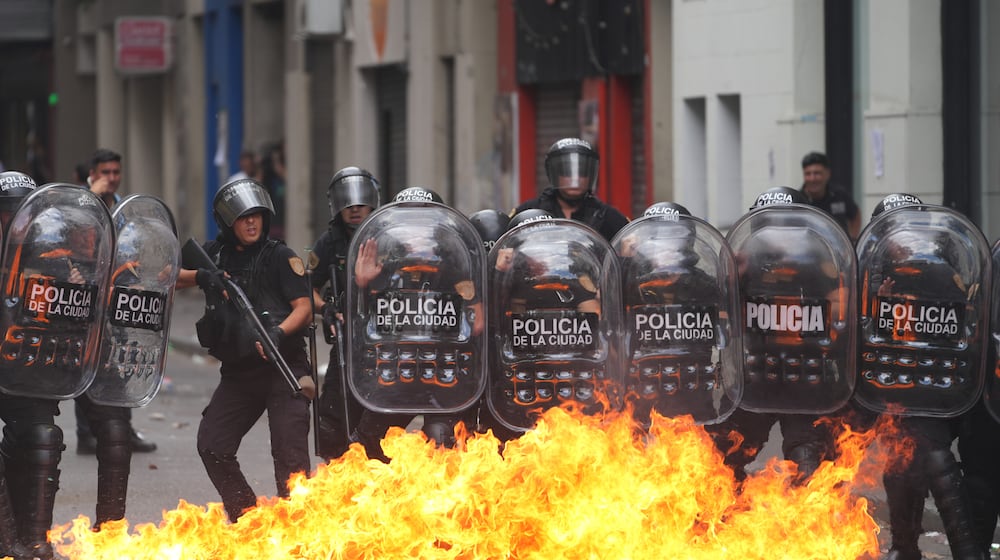 A Molotov cocktail bursts into flames in front of police during a march by unions and opposition supporters against a labor reform bill proposed by President Javier Milei's government in Buenos Aires, Argentina, Wednesday, Feb. 11, 2026.(AP Photo/Rodrigo Abd)