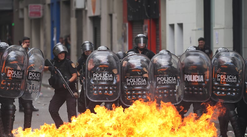 A Molotov cocktail bursts into flames in front of police during a march by unions and opposition supporters against a labor reform bill proposed by President Javier Milei's government in Buenos Aires, Argentina, Wednesday, Feb. 11, 2026.(AP Photo/Rodrigo Abd)