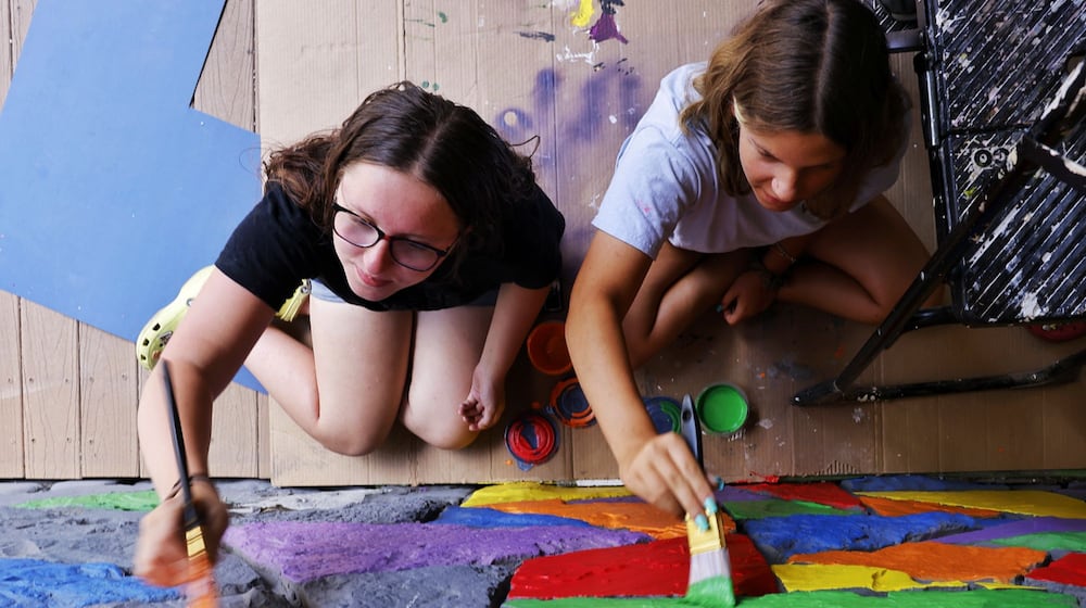 Onica Zecher, 16, left, and Gianna Frongia, 18, paint the exterior of the Art Central Foundation building on Main Street in Middletown in June 2024. NICK GRAHAM/STAFF