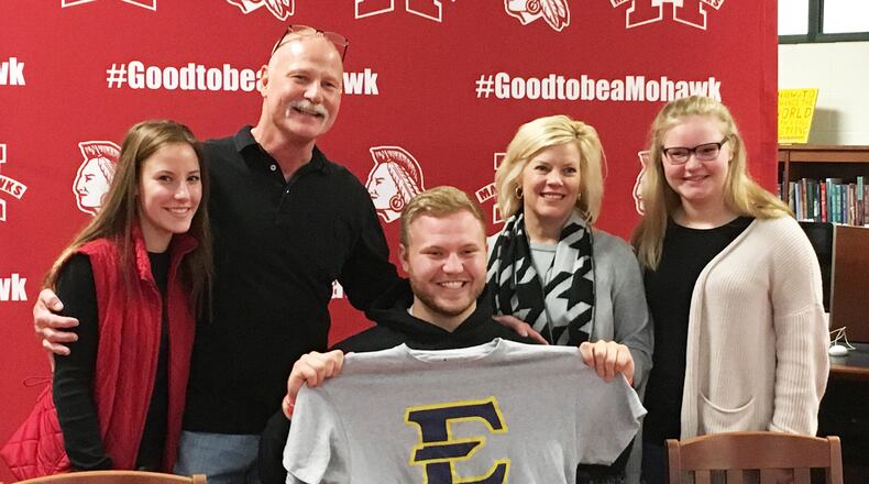 Madison’s Max Evans poses with his family — from left, Carly, Greg, Julie and Stella Evans — during Friday’s signing ceremony in the high school media center. Evans will continue his football career at East Tennessee State University. RICK CASSANO/STAFF