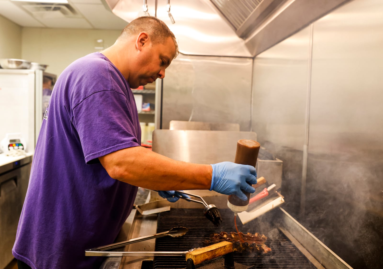 Brent Dalton cooks on the grill at his new location. Brent's Smokin' Butts & Grill has moved from their downtown location to a new location at 640 N University Blvd. in Middletown. NICK GRAHAM/STAFF