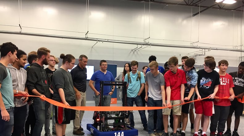 High school students from Butler Tech’s mechatronics celebrated their recently renovated and expanded learning space by using a robot they constructed to cut the ceremonial ribbon. Joining them in the celebration of the new learning space at Butler Tech’s D. Russel Lee campus in Fairfield Township were local and state politicians who praised the program. (Photo by Michael D. Clark/Journal-News)