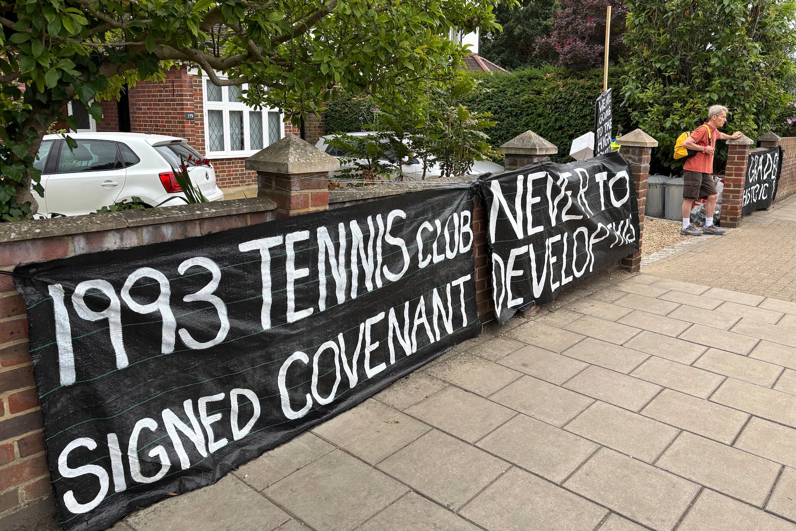 A banner opposed to Wimbledon's major expansion plan is placed outside a house leading to the All England Club where the Wimbledon Tennis Championships take place in London, Saturday, July 5, 2025. (AP Photo/Tony Hicks)