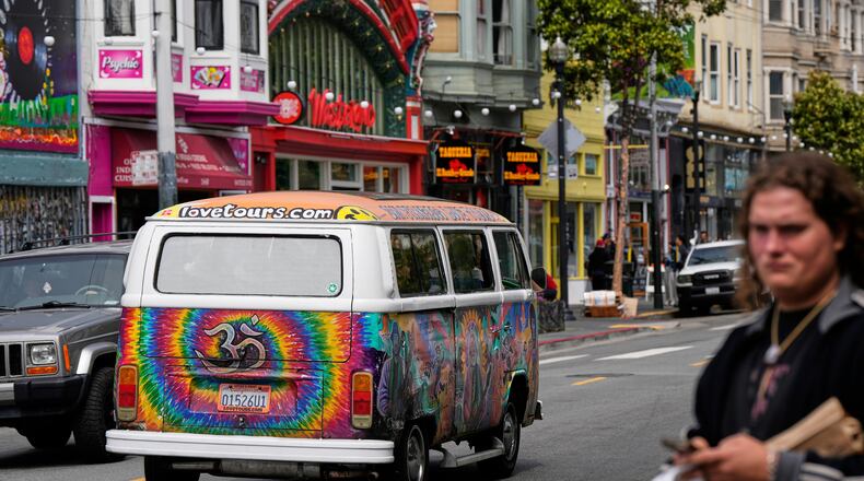 A tour van featuring a painting of musician Jerry Garcia travels through Haight Street in San Francisco, Saturday, July 19, 2025. (AP Photo/Godofredo A. Vasquez)