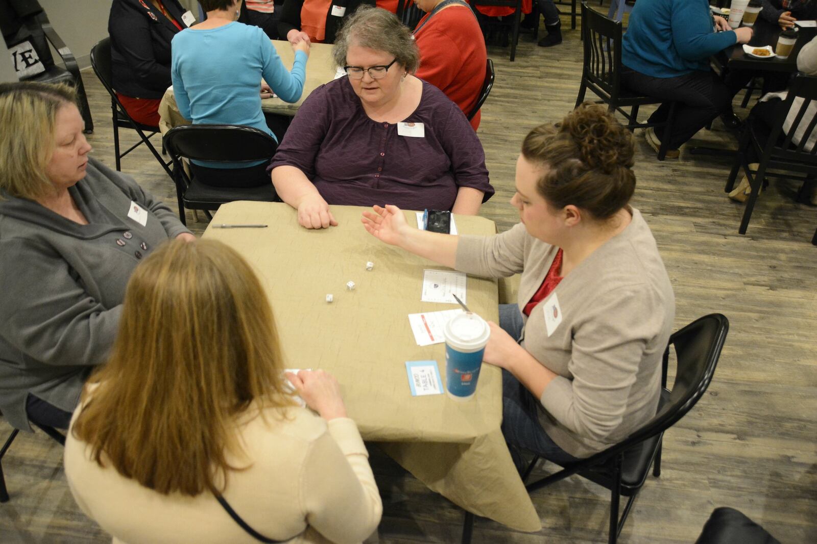 A group plays Bunco at Coffee Cup Overflowing in Fairfield Twp. The owners of Coffee Cup Overflowing say the business is struggling to make monthly rent payments. MICHAEL PITMAN/STAFF