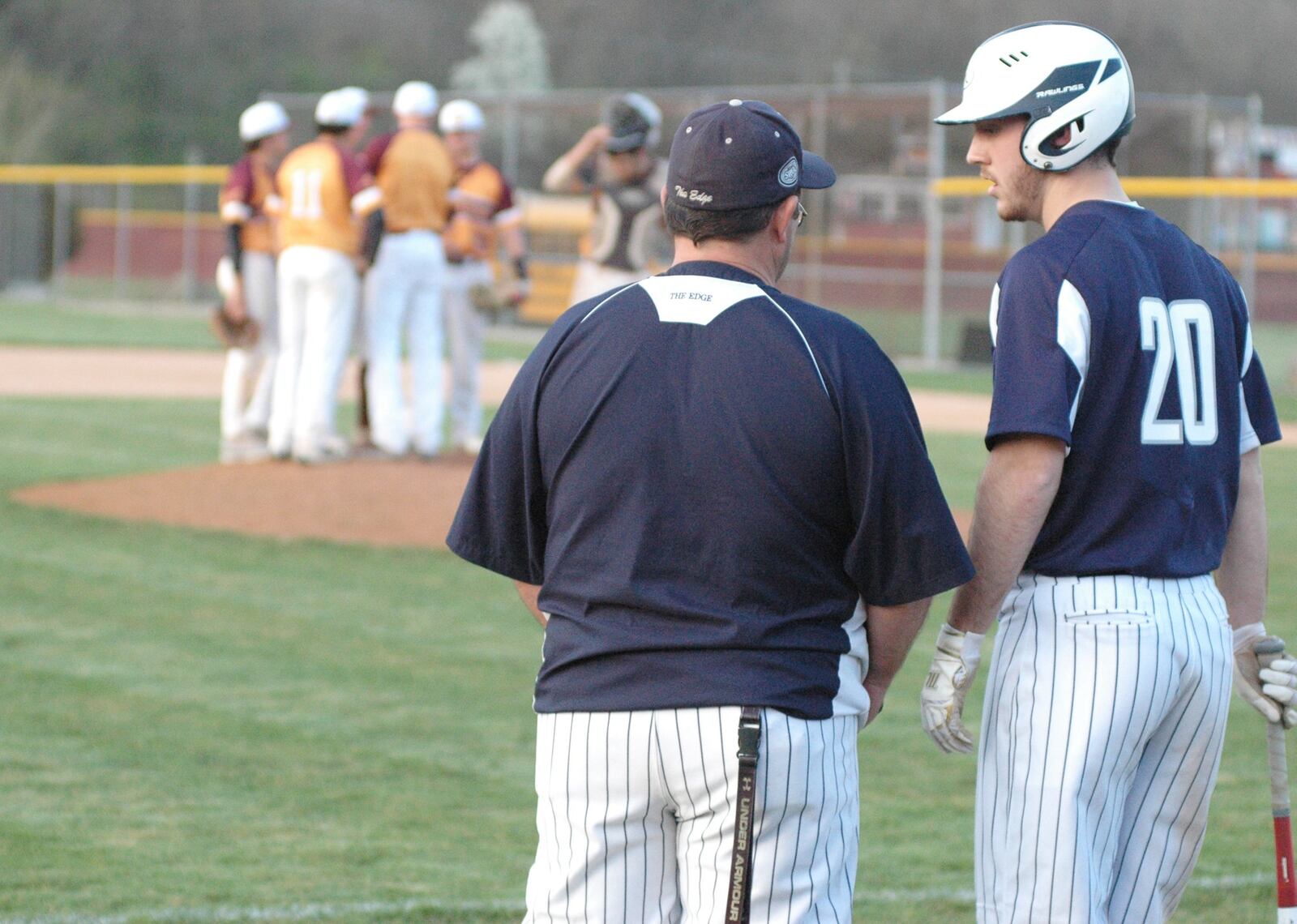 Edgewood coach Ralph Lunsford talks to Shane Watts (20) during a Ross huddle on the mound Wednesday in Ross Township. The host Rams won the Southwest Ohio Conference baseball game 13-9. RICK CASSANO/STAFF