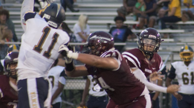 Lebanon quarterback Kyle Short fires a short pass over Springfield’s Leonard Taylor last Friday night at James VanDeGrift Stadium in Lebanon. The visiting Wildcats won 33-14. CONTRIBUTED PHOTO BY JEFF GILBERT
