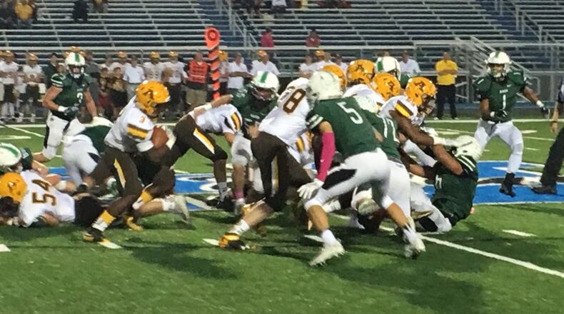 Marshall Flaig (5) is among the Badin defenders eyeing Alter running back John Bivens (3) during Friday night’s game at Hamilton’s Virgil Schwarm Stadium. RICK CASSANO/STAFF