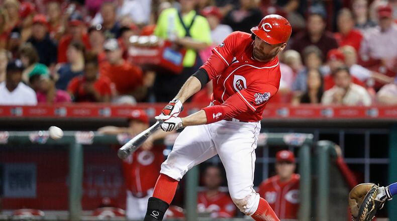 Cincinnati Reds' Joey Votto hits an RBI single off Texas Rangers starting pitcher Derek Holland during the sixth inning of a baseball game, Tuesday, Aug. 23, 2016, in Cincinnati. (AP Photo/John Minchillo)