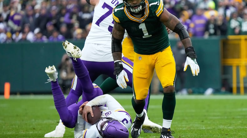 Minnesota Vikings quarterback J.J. McCarthy (9) lays on the ground after being sacked by Green Bay Packers defensive end Micah Parsons (1) during the second half of an NFL football game Sunday, Nov. 23, 2025, in Green Bay, Wis. (AP Photo/Morry Gash)