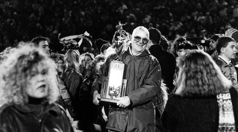 Badin High School football coach Terry Malone happily holds the trophy on Nov. 23, 1990, after the Rams captured the Division III state championship with a 16-6 victory over Richfield Revere at Paul Brown Tiger Stadium in Massillon. JOURNAL-NEWS FILE PHOTO