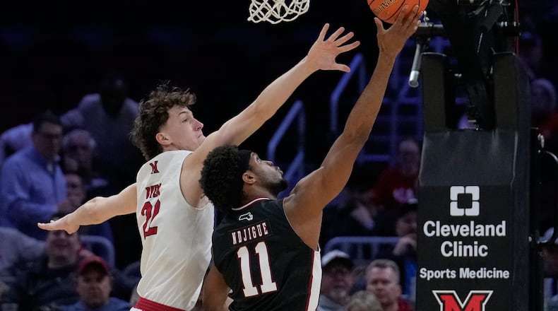 Massachusetts' Jayden Ndjigue (11) shoots as Miami (Ohio) forward Brant Byers (22) defends in the first half of an NCAA college basketball game in the quarterfinals of the Mid-American Conference tournament, Thursday, March 12, 2026, in Cleveland. (AP Photo/Sue Ogrocki)