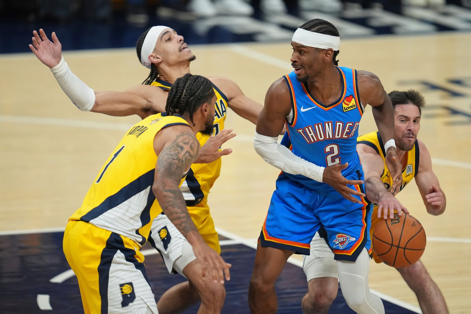 Indiana Pacers guard T.J. McConnell, right, knocks the ball away from Oklahoma City Thunder guard Shai Gilgeous-Alexander (2) as Indiana Pacers guard Andrew Nembhard defends during the first half of Game 6 of the NBA Finals basketball series, Thursday, June 19, 2025, in Indianapolis. (AP Photo/Michael Conroy)