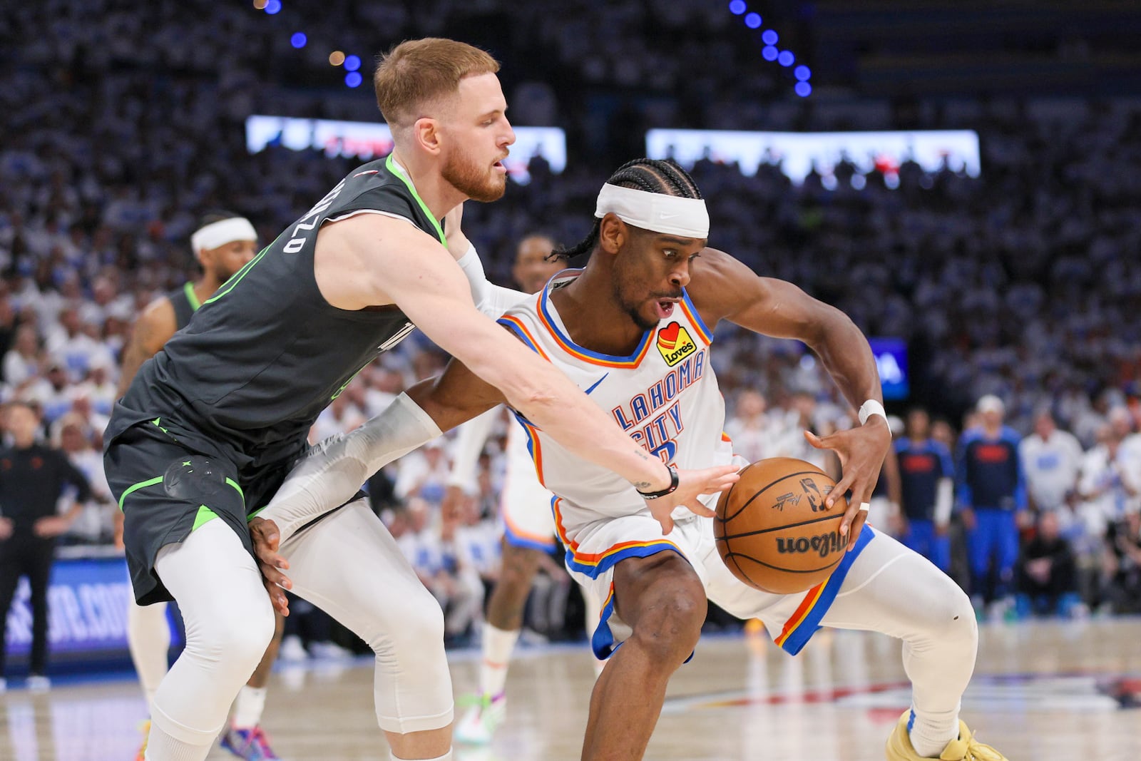 Minnesota Timberwolves guard Donte DiVincenzo, left, applies pressure on Oklahoma City Thunder guard Shai Gilgeous-Alexander during the second half of Game 1 of an NBA basketball Western Conference Finals playoff series Tuesday, May 20, 2025, in Oklahoma City. (AP Photo/Nate Billings)