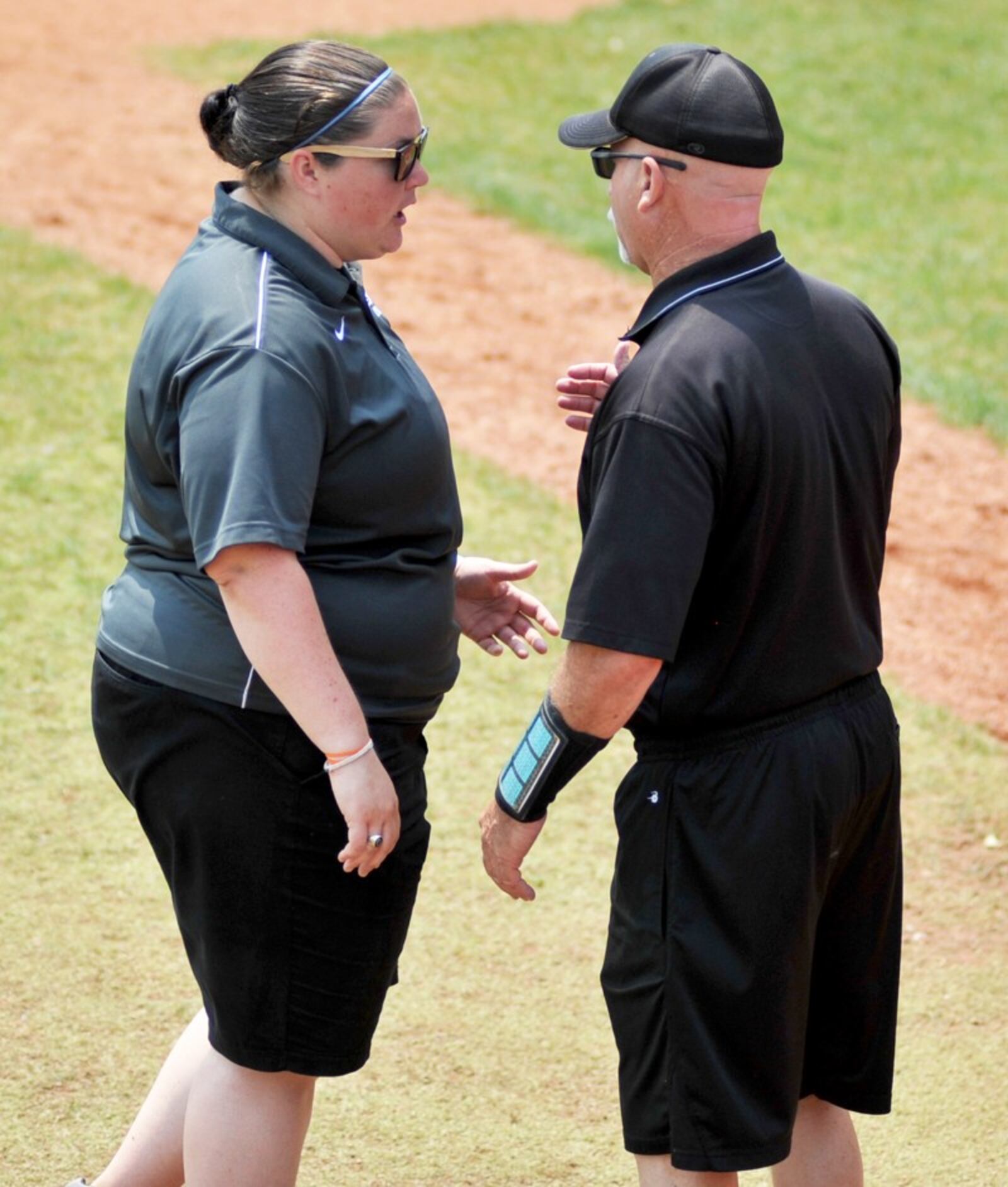 Lakota East coaches Jess Howard (left) and Dan Castner talk between innings May 31 during their 4-3 victory over Westerville Central in a Division I state softball semifinal at Firestone Stadium in Akron. RICK CASSANO/STAFF