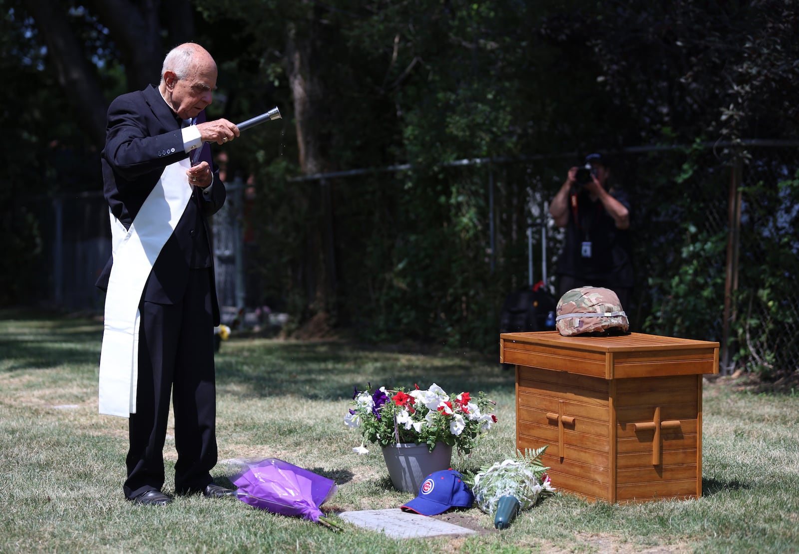 Deacon Glenn Tylutki, of Chicago Catholic Cemeteries, blesses the grave of 75-year-old Pfc. Reba C. Bailey, a former missing person cold case named Seven Doe, during a military funeral Tuesday, July 1, 2025, at Mount Olivet Catholic Cemetery in Chicago. (AP Photo/Talia Sprague)