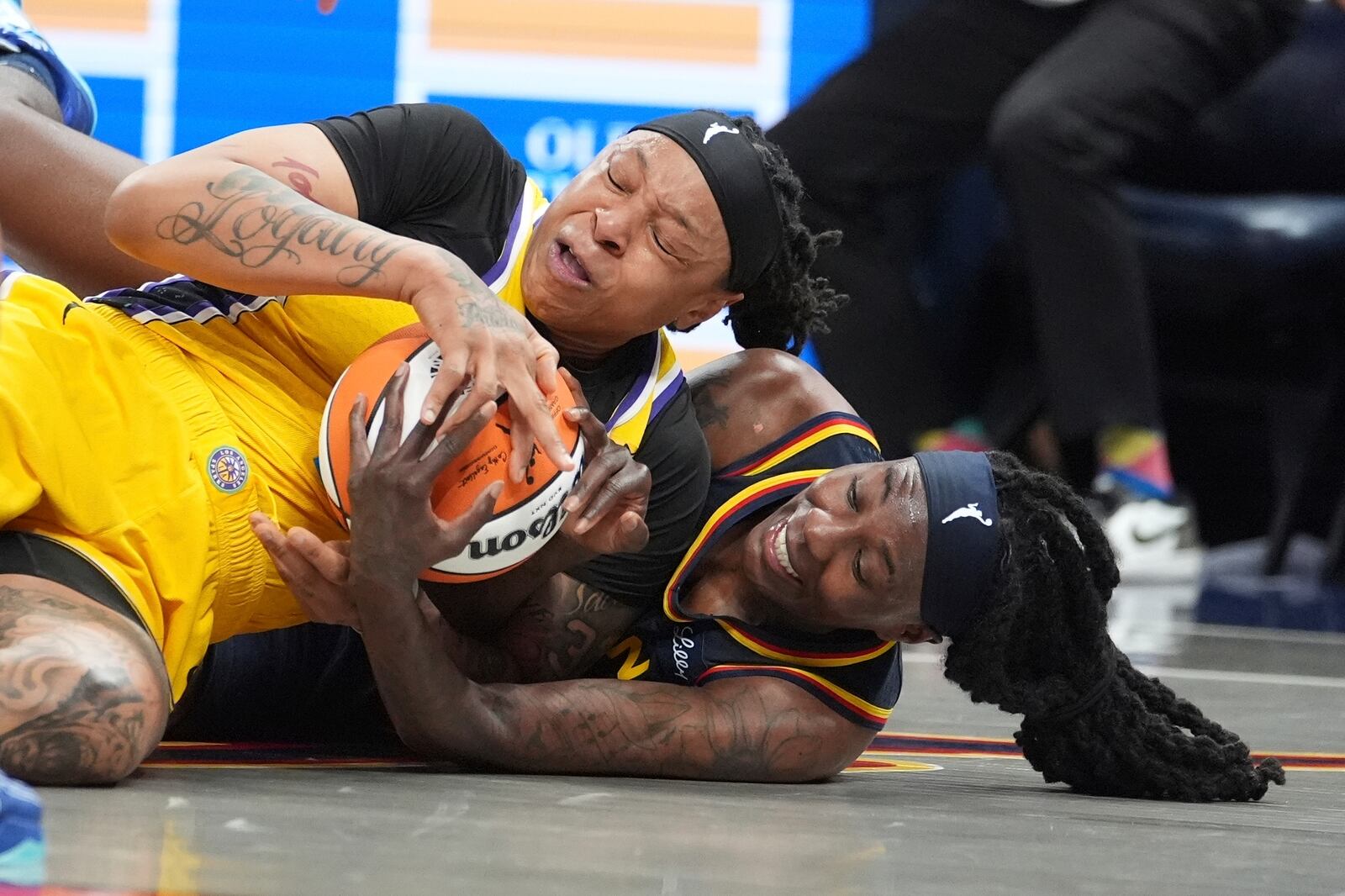 Los Angeles Sparks' Emma Cannon (32) and Indiana Fever's Natasha Howard (6) batlle for a loose ball during the second half of a WNBA basketball game, Saturday, July 5, 2025, in Indianapolis. (AP Photo/Michael Conroy)