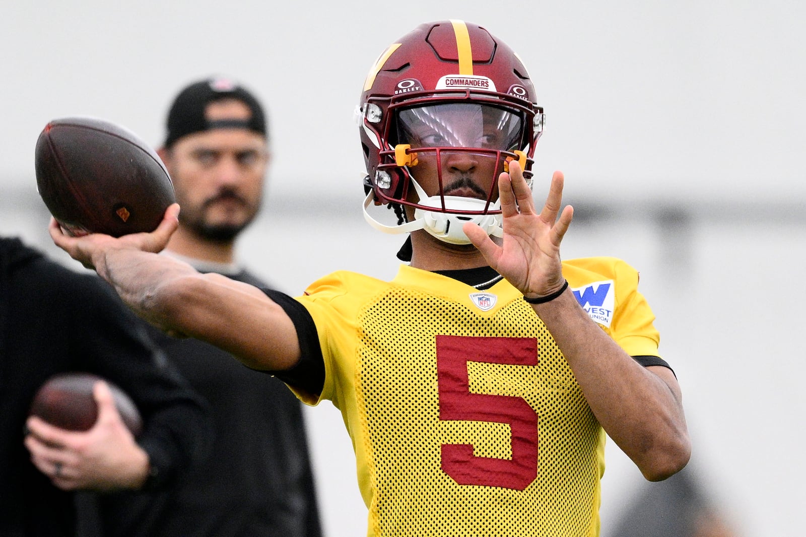 Washington Commanders quarterback Jayden Daniels (5) throws during NFL football practice, Wednesday, May 28, 2025, in Ashburn, Va. (AP Photo/Nick Wass)