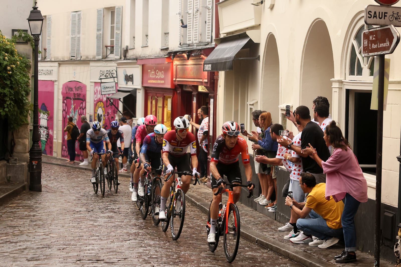 The pack rides to at the Place de Tertre in the Montmartre district, during the last stage of the Tour de France cycling race between Mantes-la-Ville and Paris, Sunday, July 27, 2025 in Paris (AP Photo/Thomas Padilla)