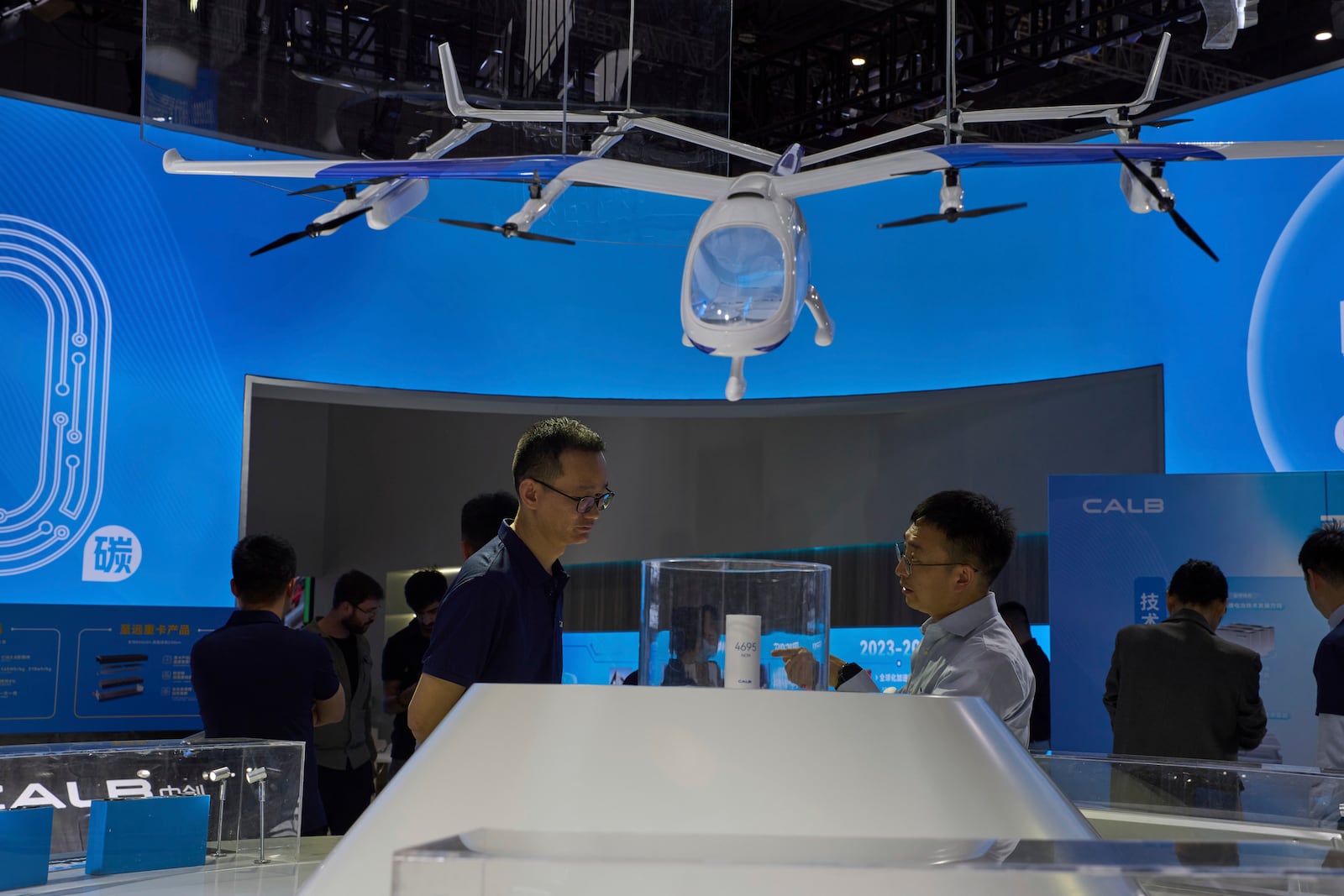 Visitors look at a model of a flying vehicle at the booth for Chinese lithium battery manufacturer CALB during the Shanghai auto show on Thursday, April 24, 2025. (AP Photo/Ng Han Guan)