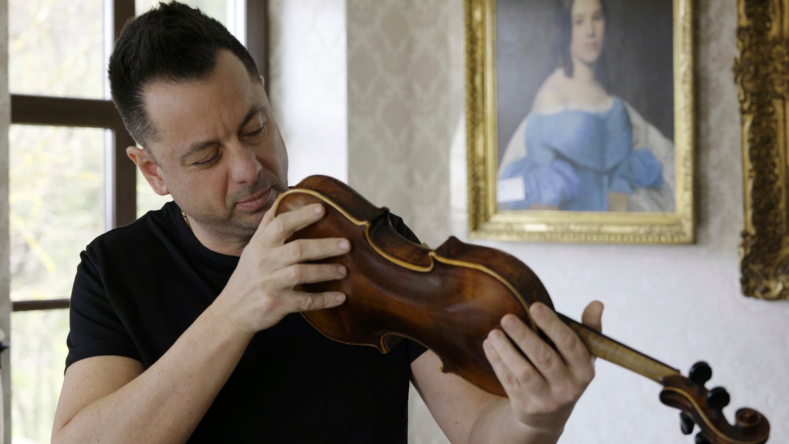 Art collector Tamás Tálosi holds a Dachau-built instrument dubbed the ''violin of hope'', in Magyarpolány, Hungary, Tuesday April 22, 2025. (AP Photo/Nikolett Csanyi)
