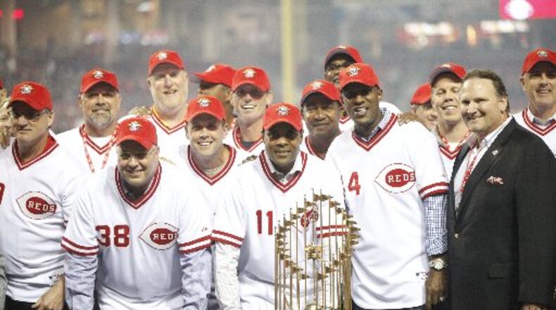 Former Reds, including Barry Larkin (11) and Eric Davis (44), pose with the World Series trophy during a 25th anniversary celebration of the 1990 World Series championship on Friday, April 24, 2015, at Great American Ball Park in Cincinnati. David Jablonski/Staff