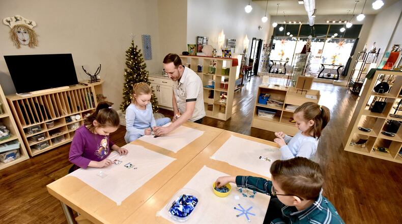 John Ferrando works on glass ornaments with his daughters, Julianna, 7, Lilly, 8, Elizabeth, 8, and son, Aaron, 10, as he gets his shop, Haute Fusion Glass Studio and Gallery, on Central Avenue in Middletown ready Wednesday, Nov. 27, 2019 for small business Saturday. Haute Fusion is one of many businesses open in downtown Middletown on small business Saturday on Nov. 30. NICK GRAHAM/STAFF