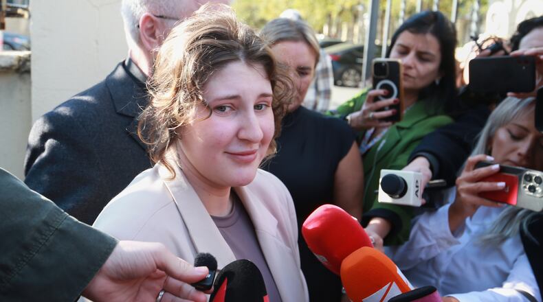 Bella May Culley, front left, 19-year-old, who was arrested upon arrival at the Tbilisi Airport in May and accused of attempting to smuggle marijuana and hashish into the country, speaks to journalists after she was released from prison near the court building in Tbilisi, Georgia, on Monday, Nov. 3, 2025, as her mother Lyanne Kennedy, stands behind. (AP Photo/Zurab Tsertsvadze)