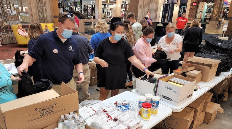 Dozens of volunteers filled backpacks with supplies for the Stuff The Bus school supply drive to help students with supplies for the coming school year. The event was held inside The Foundry at Liberty Center due to rain. NICK GRAHAM/STAFF