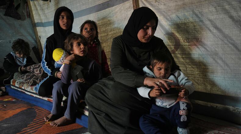 Rotana al-Regeb, who was allowed into Gaza from Egypt following the long-awaited reopening of the Rafah border crossing, reunites with her children in Khan Younis, southern Gaza Strip, Tuesday, Feb. 3, 2026. (AP Photo/Jehad Alshrafi)