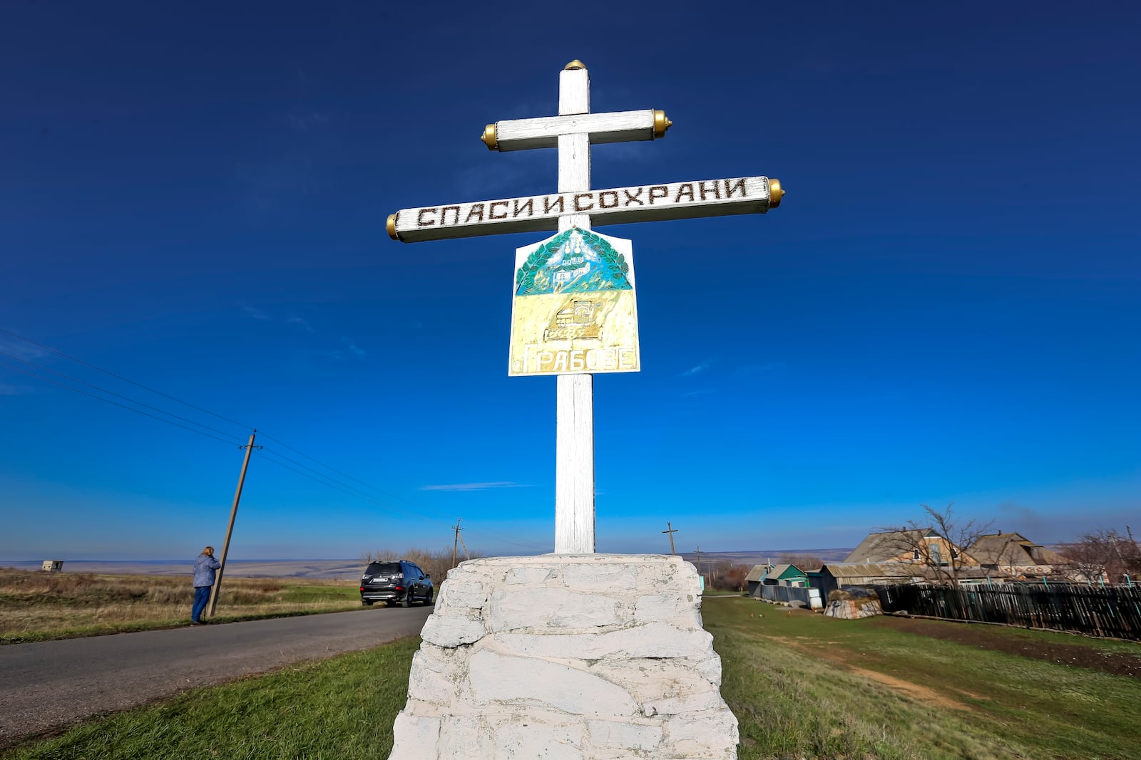FILE - An Orthodox cross with a sign reading Save and Guard, is seen with a memorial to the victims of the Malaysian Airlines MH17 plane crash, near the village of Hrabove, Russian-controlled Donetsk region of eastern Ukraine, Nov. 15, 2022. (AP Photo, File)