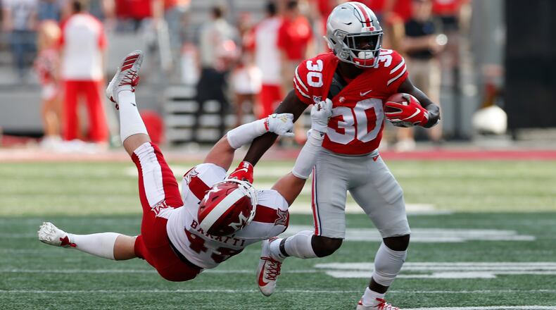 Ohio State running back Demario McCall, right, escapes the grasp of Miami (Ohio) defensive back Bart Baratti during the first half of an NCAA college football game Saturday, Sept. 21, 2019, in Columbus, Ohio. (AP Photo/Jay LaPrete)