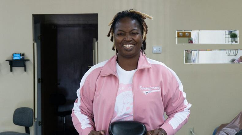 Juiquetta Harmon, who cuts hair under the name KiKi the Barber, stands behind the chair in her South Locust Street shop. JARRED WATKINS/CONTRIBUTED