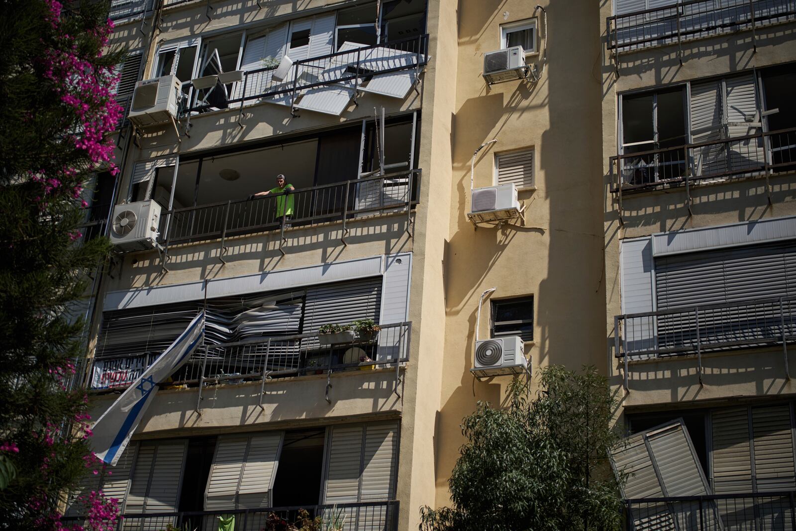 Yuval, 65, looks out from the window of his damaged apartment a day after of an Iranian missile strike in Ramat Gan, Israel, Friday, June 20, 2025. (AP Photo/Leo Correa)