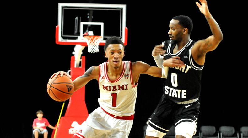 Miami's Kamari Williams, 1, brings the ball up court against Wright State's Amari Davis, 0, during the first half of a non-conference game at Millett Hall on Thursday, Dec.22. DAVID A. MOODIE/CONTRIBUTING PHOTOGRAPHER
