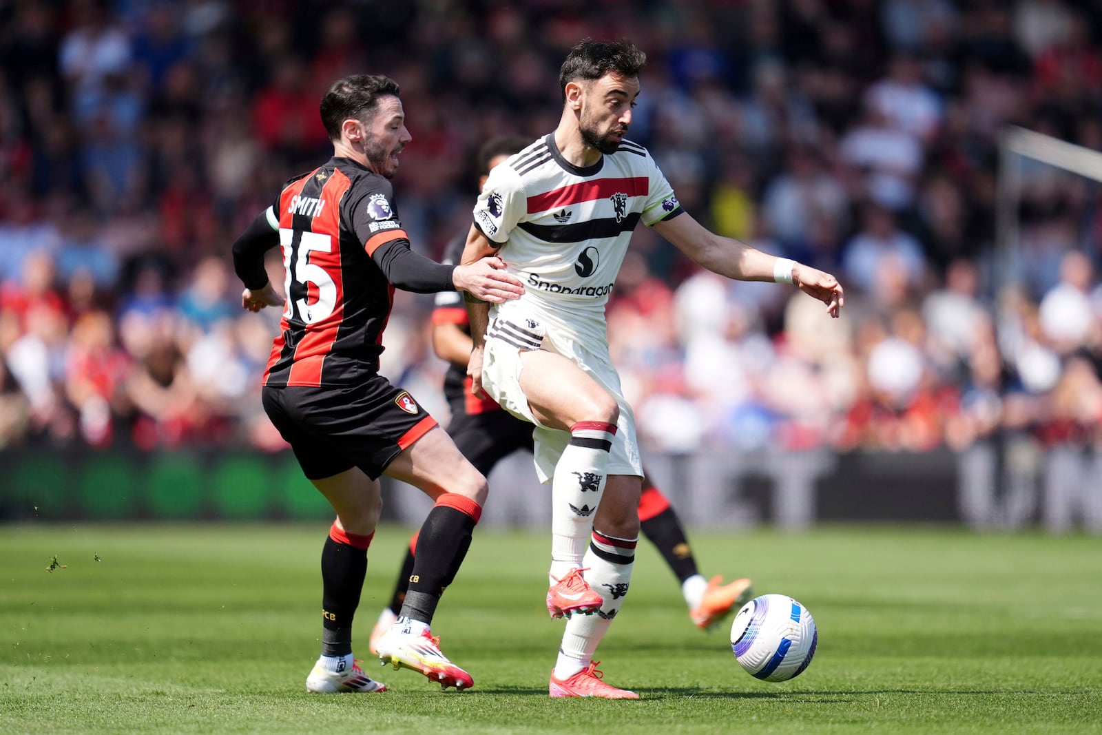 Manchester United's Bruno Fernandes, right, and Bournemouth's Adam Smith battle for the ball during the English Premier League match at Vitality Stadium, Bournemouth, England, Sunday, April 27, 2025. (Adam Davy/PA via AP)