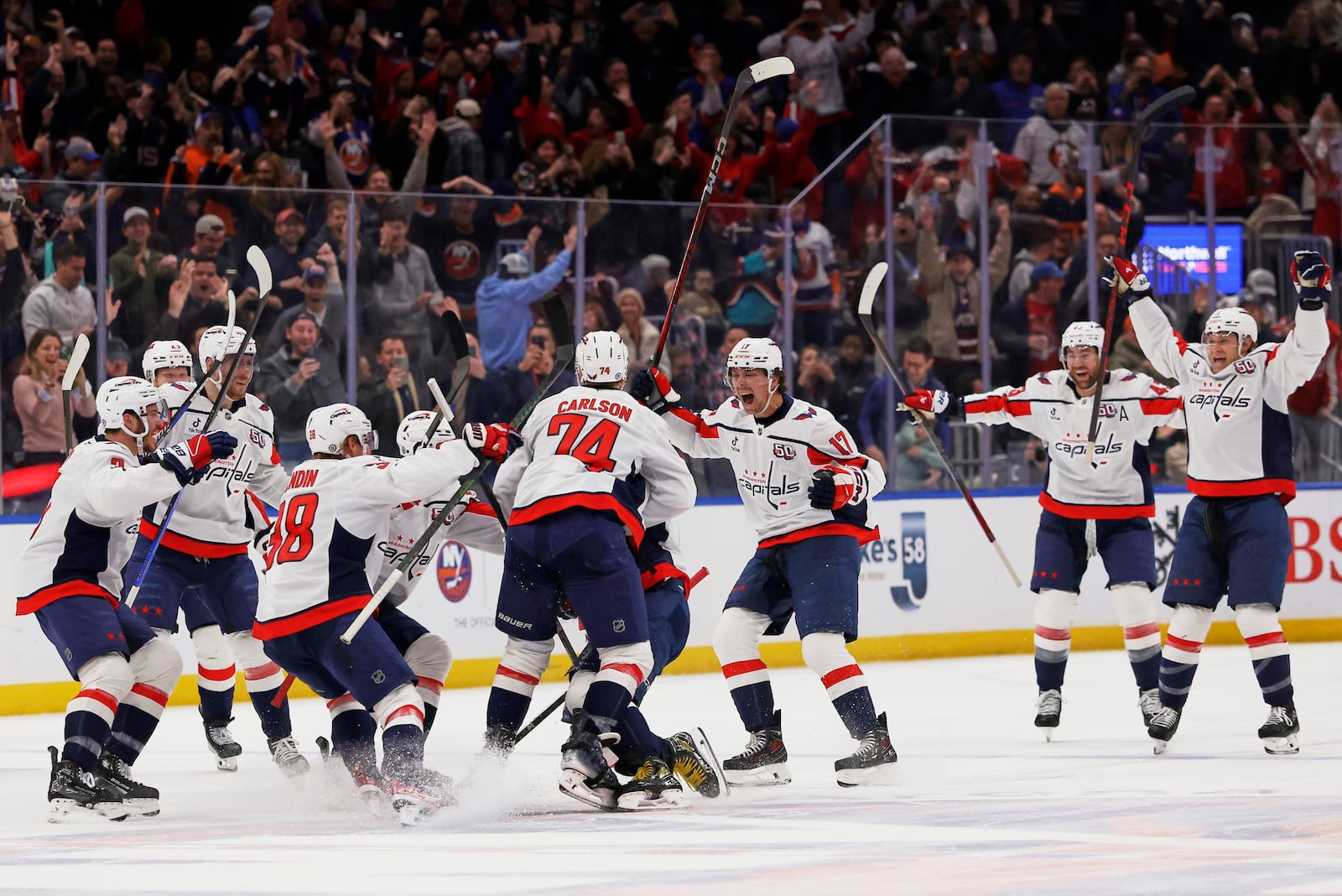 Washington Capitals left wing Alex Ovechkin (8) celebrates with teammates after scoring against New York Islanders during the second period of an NHL hockey game in Elmont, N.Y., Sunday, April 6, 2025. (AP Photo/Adam Hunger)