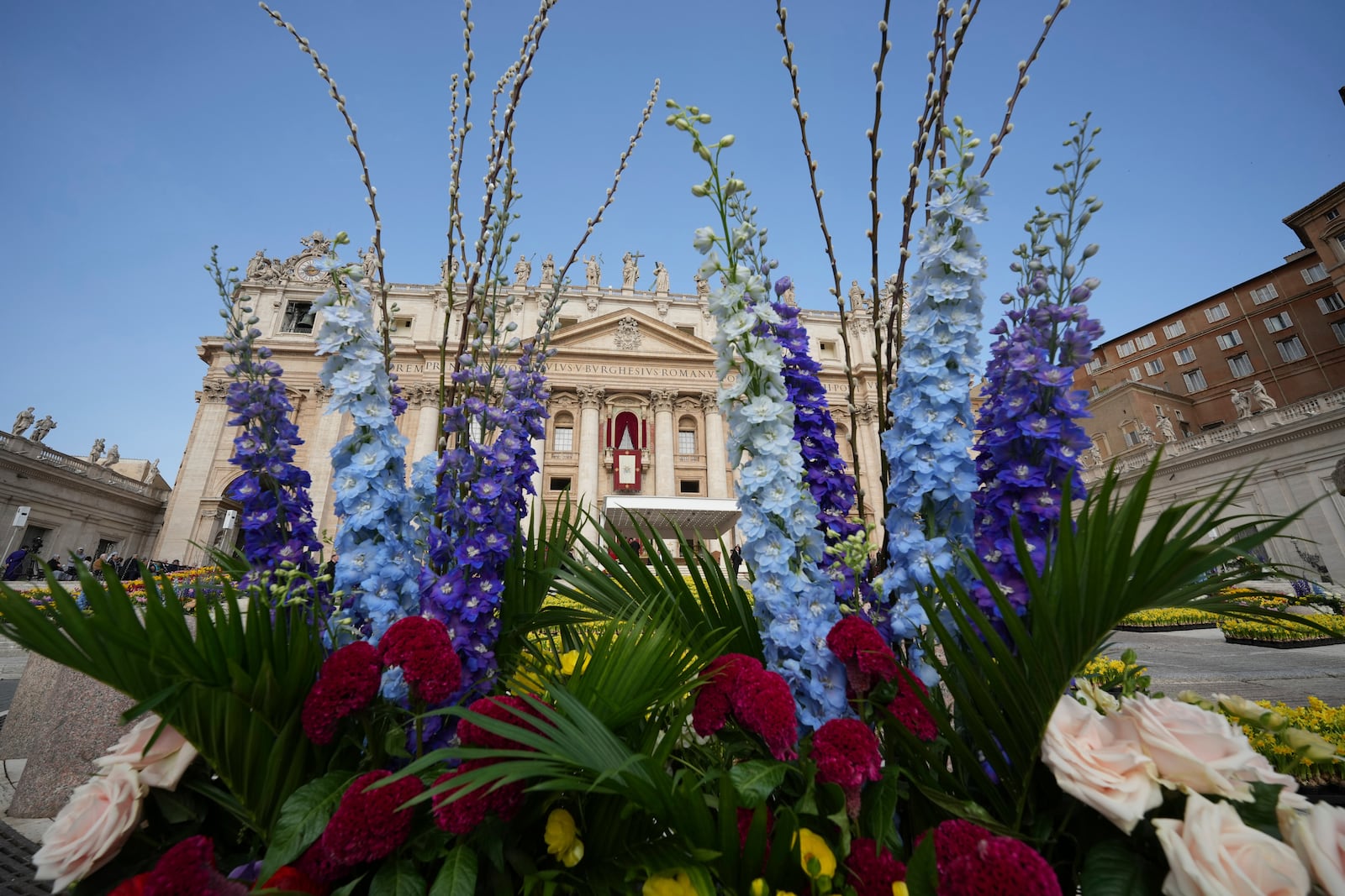 Flowers are set up for the Easter mass in St. Peter's Square at the Vatican Sunday, April 20, 2025. (AP Photo/Andrew Medichini)