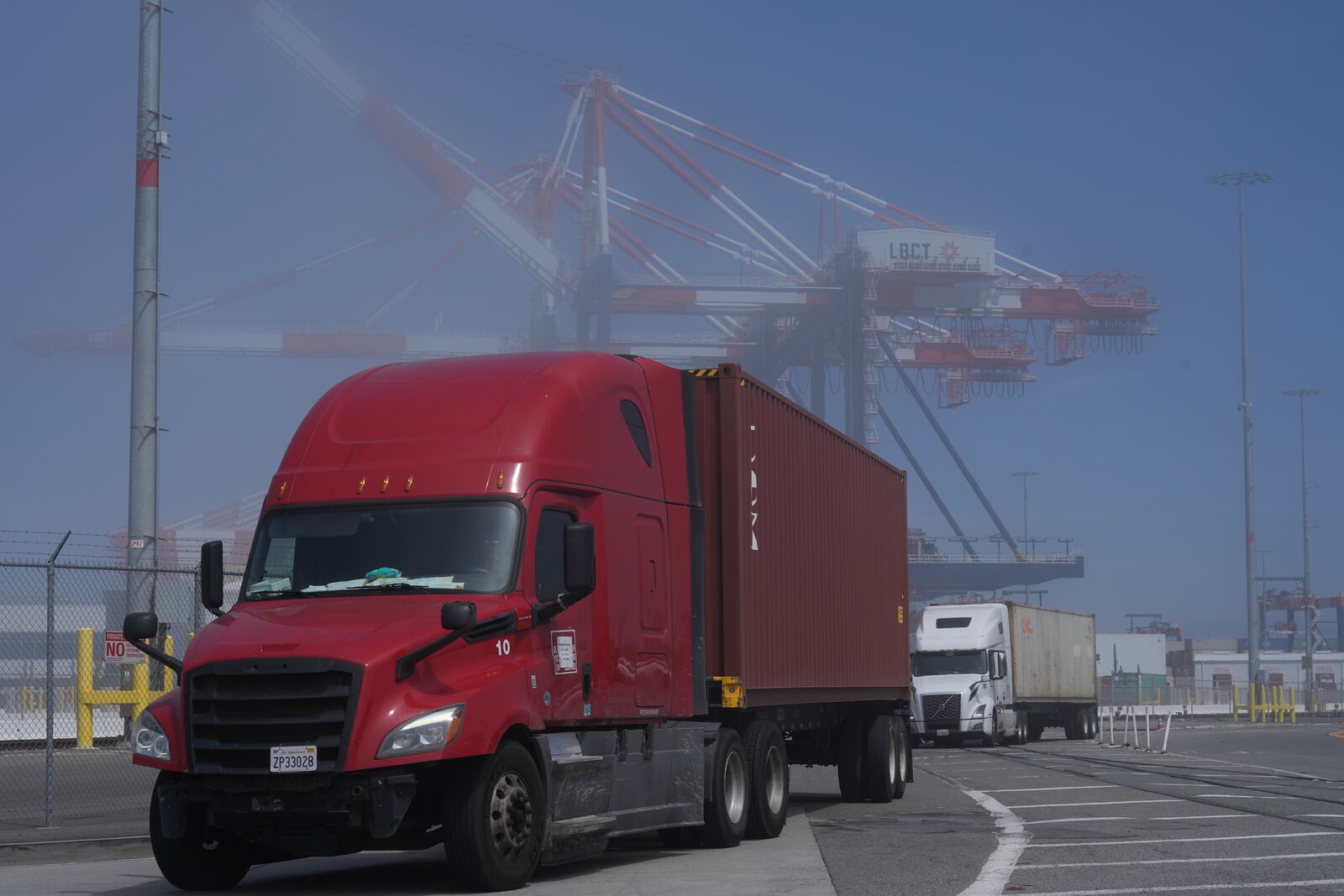 Trucks arrive at the Long Beach Container Terminal, LBCT, at Middle Harbor in the Port of Long Beach, Calif., Tuesday, April 8, 2025. (AP Photo/Damian Dovarganes)