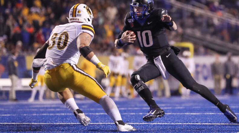 BOISE, ID - NOVEMBER 09: Quarterback Chase Cord #10 of the Boise State Broncos tries to avoid the tackle of linebacker Logan Wilson #30 of the Wyoming Cowboys during the second half on November 9, 2019 at Albertsons Stadium in Boise, Idaho. Boise State won the game 20-17 in overtime. (Photo by Loren Orr/Getty Images)
