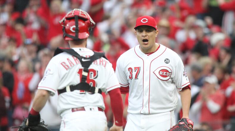 Caption: Reds reliever David Hernandez, left, reacts after recording the final out of a victory against the Pirates as catcher Tucker Barnhart watches on Opening Day on Thursday, March 28, 2019, at Great American Ball Park in Cincinnati. David Jablonski/Staff