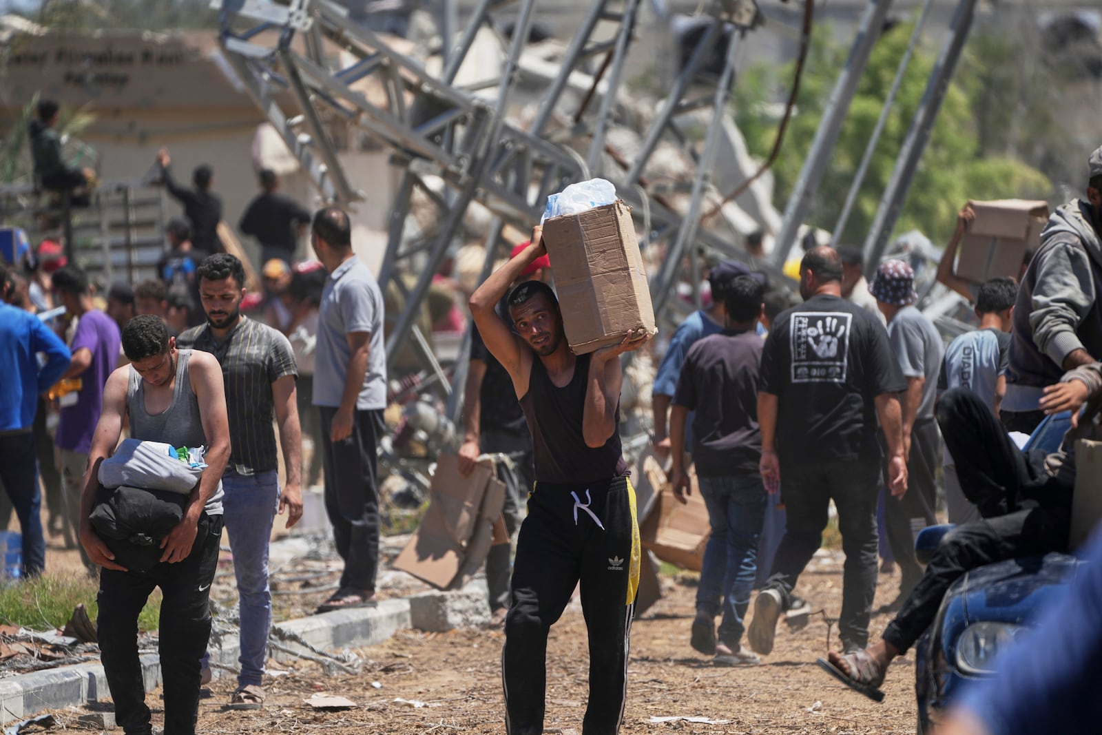 Palestinians carry boxes and bags containing food and humanitarian aid packages delivered by the Gaza Humanitarian Foundation, a U.S.-backed organization approved by Israel, in Khan Younis, southern Gaza Strip, on Thursday, May 29, 2025. (AP Photo/Abdel Kareem Hana)