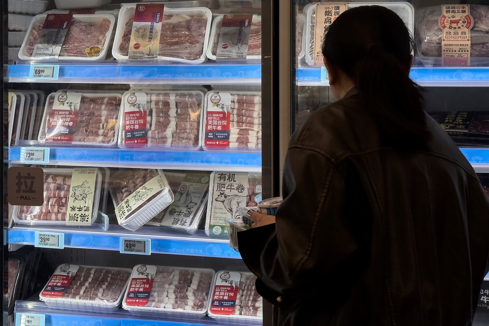 A woman looks at the imported frozen beefs from the United States and Australia on display for sale at the Hema supermarket, in Beijing, Tuesday, April 8, 2025. (AP Photo/Andy Wong)
