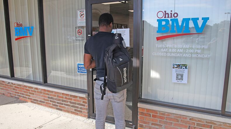 A man reads a sign on the door of the Ohio BMV testing center in the Park Shopping Center on Thursday, Sept. 21, 2023. BILL LACKEY/STAFF