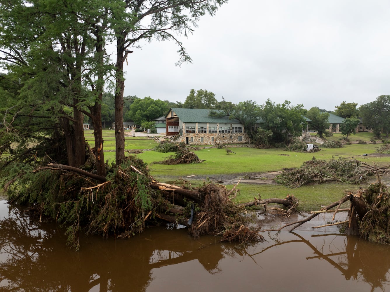 A damaged hall at Camp Mystic on the South Fork Guadalupe River, foreground, in Hunt, Texas, on Saturday, July 5, 2025. (Carter Johnston/The New York Times)