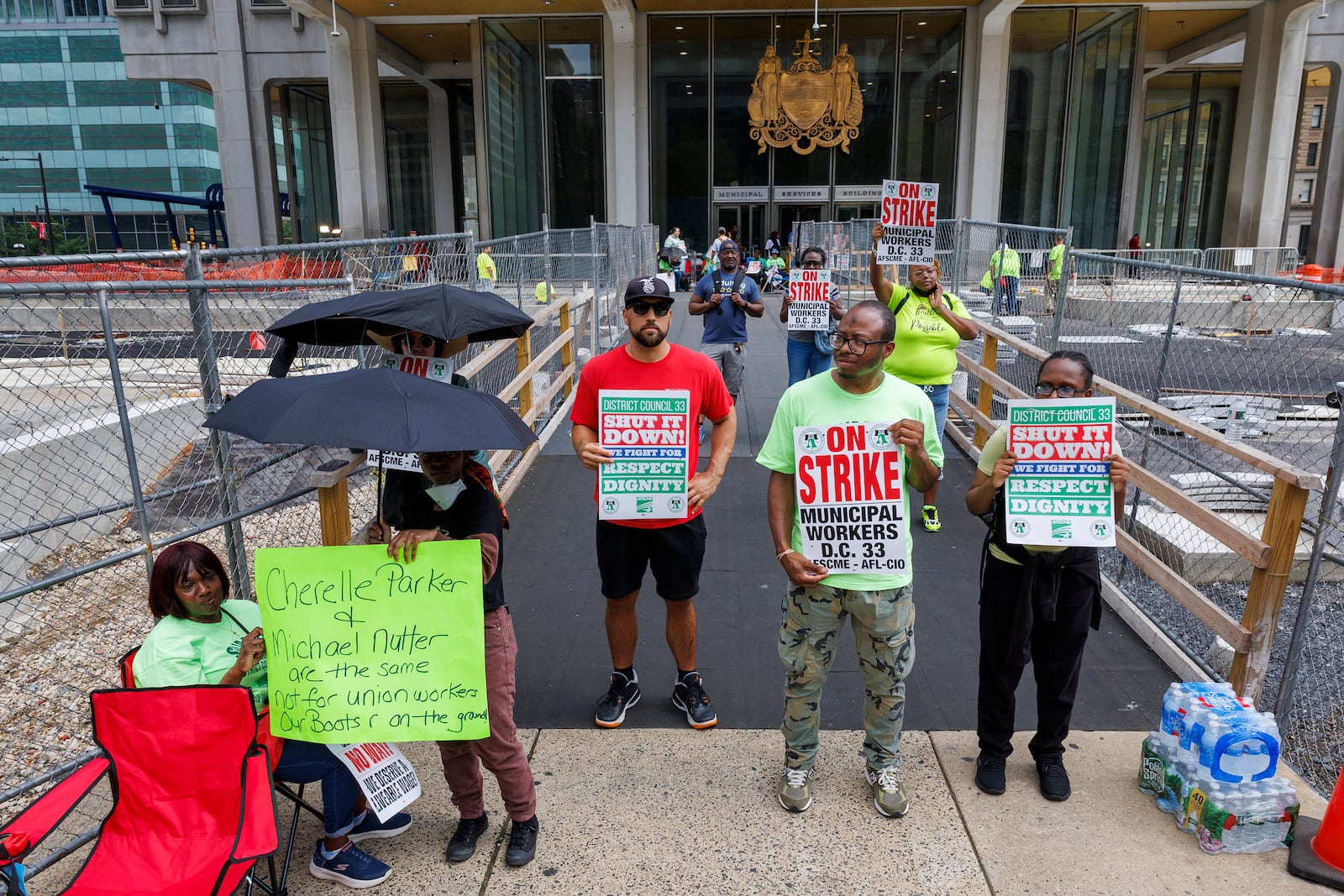 Members of Philadelphia municipal workers, AFSCME District Council 33 hold signs as they stand outside the Municipal Services Building across from City Hall, on Tuesday, July 1, 2025. (Alejandro A Alvarez/The Philadelphia Inquirer via AP)